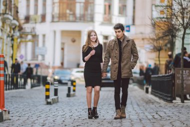 Kentsel modern genç aşk çift romantik konuşma yürüyüş, bir tarih el ele tutuşarak. Eski Avrupa caddesinde genç çok kültürlü Türk esmer ve Kafkas çift. Sonbahar ilkbahar havası