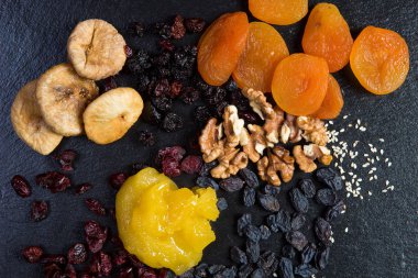 Şekersiz doğal ürünlerden yapılmış bir tatlı tatlı temasıdır. Makroyu kapatın portre tatlı kuru meyve kurmak ceviz, kiraz ve kızılcık üzümlü incir bal ve susam ve keten tohumu