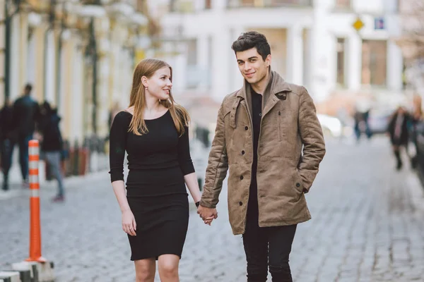 都市现代年轻爱情夫妇走浪漫说话，牵手约会。年轻的多元文化土耳其黑发和高加索夫妇在古老的欧洲街道。秋春天气 — 图库照片