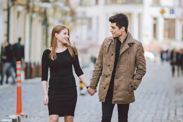 Urban modern ung kärlek par promenader romantisk pratar, hålla händerna på en dejt. Unga mångkulturella turkiska brunett och kaukasiska par på gamla europeiska gatan. Höst vårväder — Stockfoto