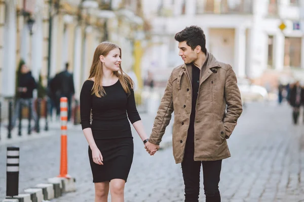 Urban modern ung kärlek par promenader romantisk pratar, hålla händerna på en dejt. Unga mångkulturella turkiska brunett och kaukasiska par på gamla europeiska gatan. Höst vårväder — Stockfoto