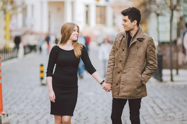 Urbano moderno jovem casal amor andando romântico falando, de mãos dadas em um encontro. Jovem morena multicultural turca e casal caucasiano na velha rua europeia. Outono tempo de primavera — Fotografia de Stock