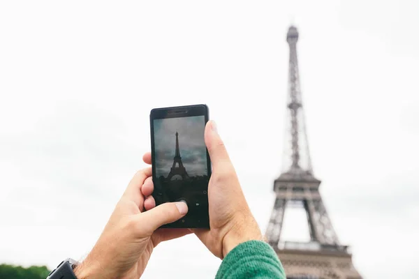 Ručičky kavkazské mužské turistické blogger dělají nejvýznamnější zajímavosti fotografie francouzského jazyka Eiffel Tower používající smartphone — Stock fotografie