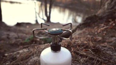 Yakın çekim kompakt bir turist gazı brülör yanma propan Butan gaz. Bir sırt çantası ile yürüyüş gezisi için gaz balon. Yürüyüş yapmak için şeyler