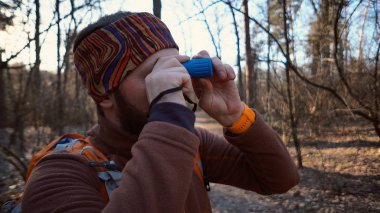 Turist Gezgininden bir sakal ve ormanda doğa peyzaj üzerinde utanç verici boru bakarak bir sırt çantası ile Kafkas adam. Bir turist teleskop yaban hayatı bakıyor