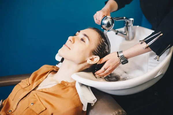 Belleza, cuidado del cabello y el concepto de la gente - mujer joven feliz con la cabeza de lavado peluquería en el salón de belleza — Foto de Stock