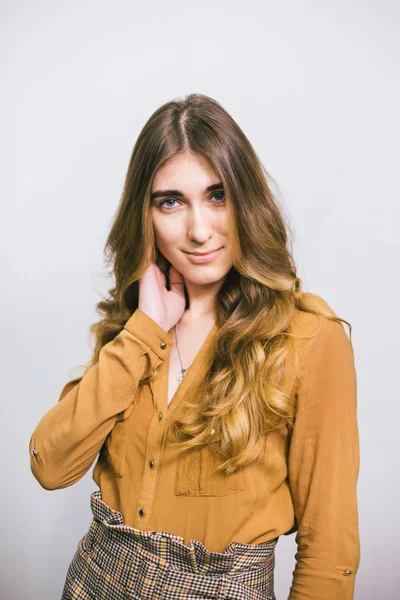 Retrato de mujer hermosa con el pelo largo rizado sobre fondo blanco. Maquillaje, moda, belleza — Foto de Stock