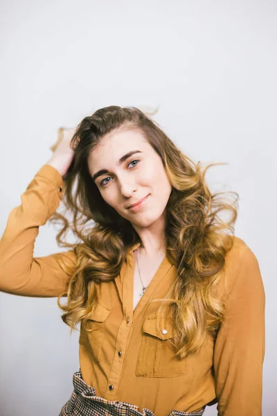 Retrato de mujer hermosa con el pelo largo rizado sobre fondo blanco. Maquillaje, moda, belleza — Foto de Stock