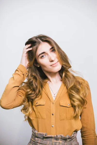 Retrato de mujer hermosa con el pelo largo rizado sobre fondo blanco. Maquillaje, moda, belleza — Foto de Stock