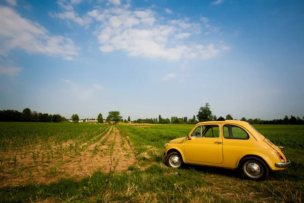 Vecchia piccola auto gialla retrò si trova in un campo in Europa Italia 2013 — Foto Stock