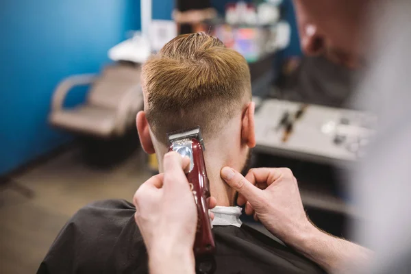 理髪店でトレンディなヘアカットを得る男のショットを閉じる。男性ヘアスタイリスト提供クライアント マシンと櫛を使用してのヘアカット — ストック写真