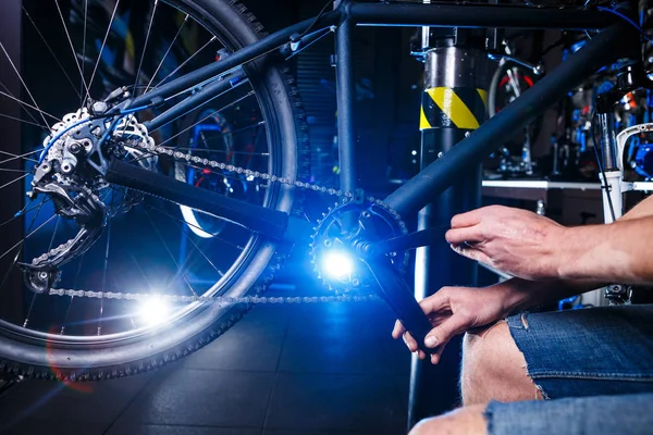 Nahaufnahme der Menschenhände Fahrradmechaniker in der Werkstatt stellen und reparieren auf Raten die Fahrradkurbel, Fahrradkettenblätter — Stockfoto