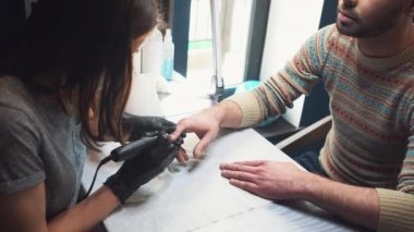 Mens manikür. Manikür makinesi ile insan için profesyonel manikür. Güzellik salonunda manikür yaptıran bir adam. Beautician master budama ve cuticles kaldırır