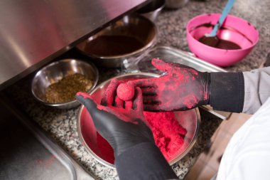 Tema pişirme çikolata trüf. Yakın çekim el Genç Kafkas kadın ve erkek dövme ve üniforma ile aşçı hazırlar, yuvarlak balltake kek tatlılık yapar. Confectioner ahududu puer kapsar