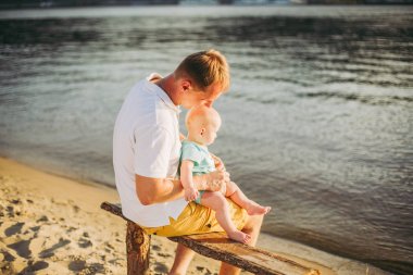 Konu rekreasyon baba ve küçük oğlu. Genç beyaz baba, Kiev kasabasına bakan ve Dinyeper nehrini tutan ahşap bankta oturur, bankalar daki kumlu plajda yeni yürümeye başlayan bir bebeğe sarılır.