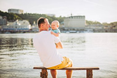 Konu rekreasyon baba ve küçük oğlu. Genç beyaz baba, Kiev kasabasına bakan ve Dinyeper nehrini tutan ahşap bankta oturur, bankalar daki kumlu plajda yeni yürümeye başlayan bir bebeğe sarılır.