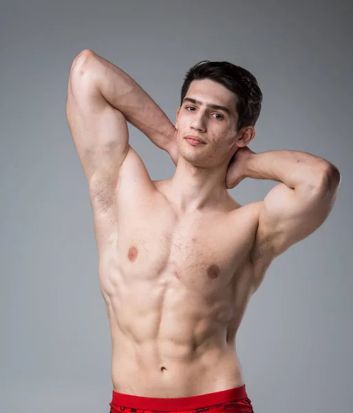 Studio portrait d'un jeune homme caucasien brune sur fond gris posant. Puberté thème, problème de peau, l'acné de l'adolescence — Photo