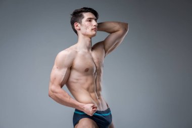 Gri arka planda stüdyo portre Genç beyaz adam poz. Ergenlik teması, problem cilt, Genç akne. Kafkas atlet Fitness. Alerji spor beslenme, takviyeleri steroidler
