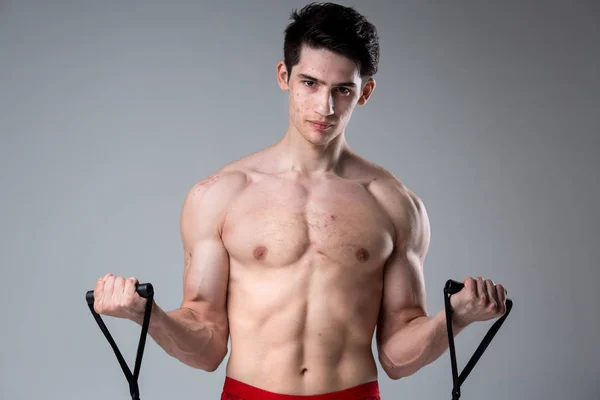 Studio portrait jeune homme caucasien sur fond gris posant. thème de la puberté, problème de peau, l'acné de l'adolescence. Athlète caucasien utilise des bandes pour la forme physique. Nutrition sportive allergique, suppléments stéroïdes — Photo