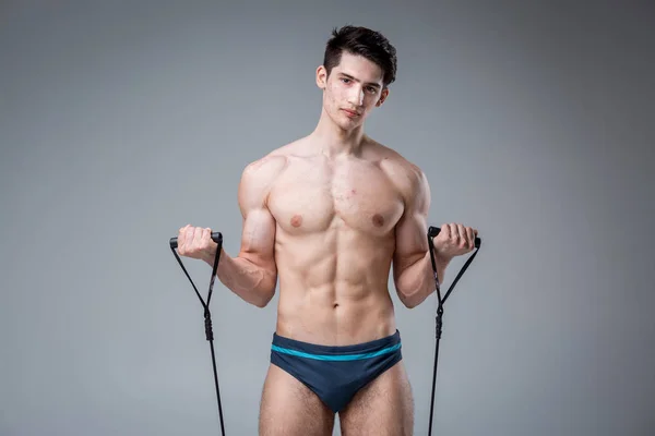 Studio portrait young Caucasian man on gray background posing. theme of puberty, problem skin, teen acne. Caucasian athlete uses banding for fitness. Allergy sports nutrition, supplements steroids — Φωτογραφία Αρχείου