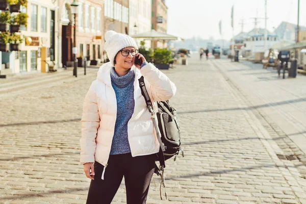 Кавказька Туристична дівчина використовує телефон, ручне виклику смартфон на Копенгаген Нюхавн, Європа добре відома Туристична привабливість. жінка жінка на воді канал порту області Cobenhavn, Данія, Скандинавії — стокове фото