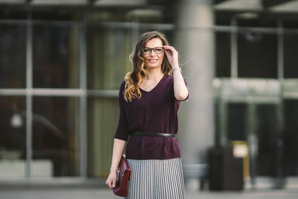 Mujer de negocios parada en la calle contra el edificio de oficinas. Mujer de negocios de la ciudad trabajando. Mujer de negocios retrato sonriendo con gafas. Mujer posando fuera de oficina edificio verano traje de negocios — Foto de Stock