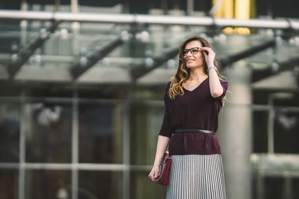 Mujer de negocios parada en la calle contra el edificio de oficinas. Mujer de negocios de la ciudad trabajando. Mujer de negocios retrato sonriendo con gafas. Mujer posando fuera de oficina edificio verano traje de negocios — Foto de Stock