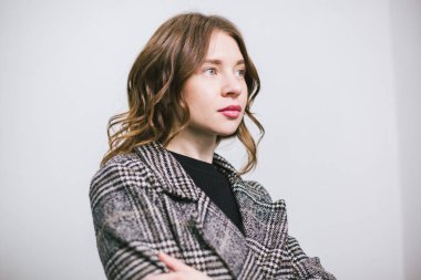 Portre beyaz arka plan üzerinde genç güzel beyaz kadın. Avrupalı kız modeli stüdyoda duvar arka plan poz. Ceket ciddi duygu ve kıvırcık dalgalı saç İş kadını