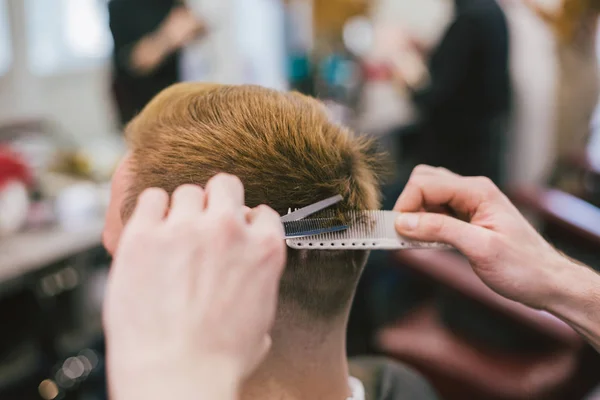 Barber Making Haircut Bearded Man In Barbershop. Professional stylist cutting client hair in salon. Barber using scissors and comb. Skillful hairdresser cutting male hair. Hair Care Service Concept — Stock Photo, Image