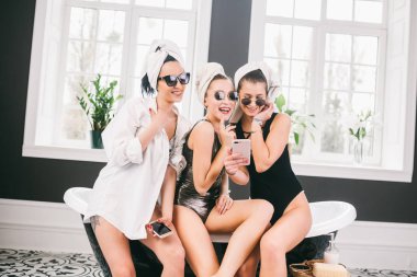 Spa'daki mutlu arkadaş grubunu gösteren resim. kafalarında havlu olan kızlar eğlenir ve evde selfie çekerler. Dostluk, kozmetik, pijama partisi konsepti. Otelde bir gelin ile Hen parti