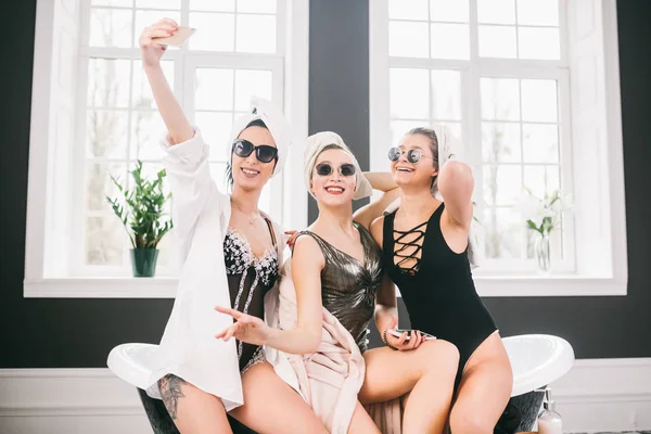Bild som visar grupp av lyckliga vänner i Spa. flickor med handdukar på huvuden ha kul och ta Selfie hemma. Vänskap, kosmetiska, slummer Party Concept. Möhippa med en brud på hotellet — Stockfoto