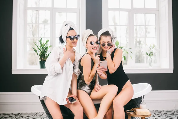 Foto toont groep van gelukkige vrienden in Spa. meisjes met handdoeken op hoofden met plezier en het nemen van selfie thuis. Vriendschap, cosmetische, Slumber partij concept. Kip partij met een bruid in het Hotel — Stockfoto