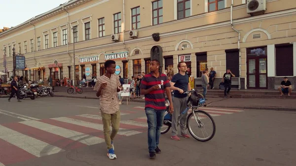 Ukraina, Kijów, 7 lipca 2019. deptak w centrum miasta. Stara historyczna ulica w Kijowie. wiele osób, tłum turystów spacery w weekend wakacji o zachodzie słońca w lecie. Rowerzysta na wypożyczenie roweru — Zdjęcie stockowe