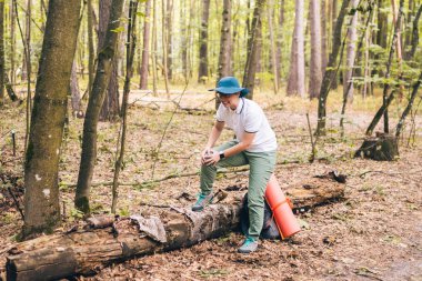 Ormanda seyahat sırasında diz ağrısı hissetmekte sorun olan genç kadın. Kampa giderken yaralanma. kadın turist ormanda bacağından yaralandı ve yaralandı. Yolculukta sağlık sorunu. Tema Sigorta Şirketi