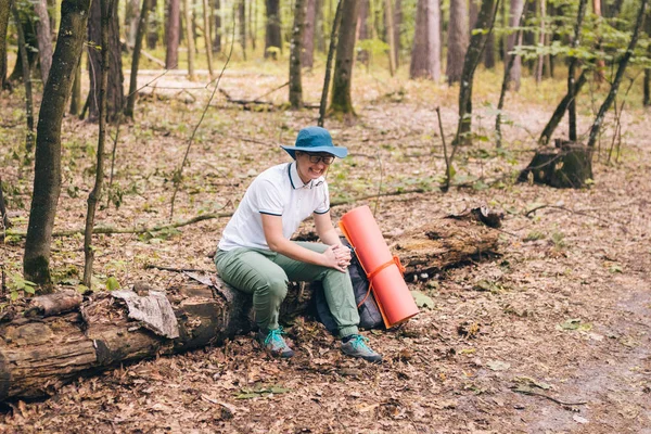 Mujer joven que tiene problemas para sentir dolor de rodilla durante el viaje en el bosque. Lesión de camino al campamento. turista femenina tiene lesión en la pierna en el bosque y se lastima. Problema de salud en viaje. Tema Compañía de seguros — Foto de Stock