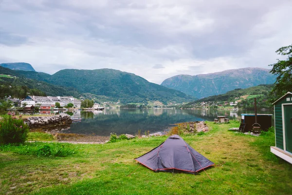 Peisaj fiord norvegian cu cort de camping. Aventură Norvegia. Cort de camping la fiord sălbatic pitoresc, un mal de lac cu lanț montan în fundal Norvegia . — Fotografie de stoc gratuită