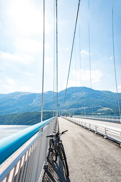 Tema de mountain bike na Escandinávia. turista humano em capacete e sportswear em bicicleta na Noruega em Hardanger Bridge ponte suspensa jogado através do fiorde Hardanger no sudoeste da Noruega — Fotografia de Stock