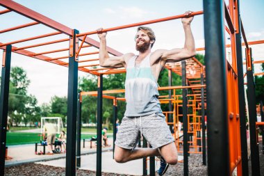 güçlü atlet yatay çubuk üzerinde pull-up yapıyor. Kaslı adam parkta yatay barda yukarı çekiyor. Egzersiz sırasında Jimnastik Bar. eğitim strongmanoutdoor park spor salonu. Man Egzersiz spor salonu Açık yapıyor