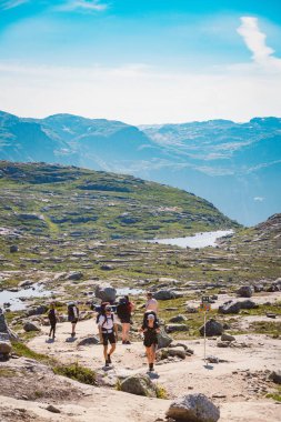 26 Temmuz 2019. Trolltunga üzerinde Norveç turistik rota. İnsanlar turistler thetrolltunga ince güneşli havalarda Norveç dağlarında yürüyüş gidin. Yürüyüş sırt çantası teması