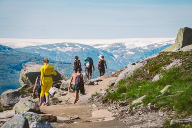 26 Temmuz 2019. Trolltunga üzerinde Norveç turistik rota. İnsanlar turistler thetrolltunga ince güneşli havalarda Norveç dağlarında yürüyüş gidin. Yürüyüş sırt çantası teması