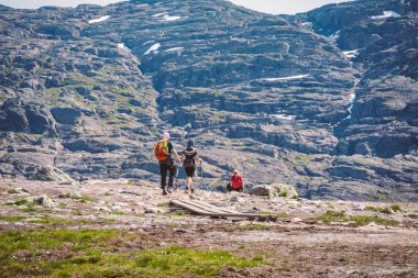 26 Temmuz 2019. Trolltunga üzerinde Norveç turistik rota. İnsanlar turistler thetrolltunga ince güneşli havalarda Norveç dağlarında yürüyüş gidin. Yürüyüş sırt çantası teması