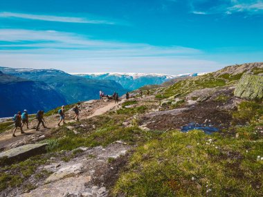 26 Temmuz 2019. Trolltunga üzerinde Norveç turistik rota. İnsanlar turistler thetrolltunga ince güneşli havalarda Norveç dağlarında yürüyüş gidin. Yürüyüş sırt çantası teması