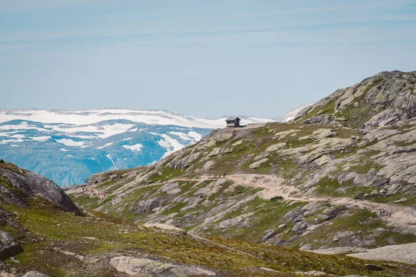 26 de julio de 2019. Noruega ruta turística en la trolltunga. La gente turistas van de excursión en las montañas de Noruega en buen tiempo soleado a la rolltunga. Mochila de senderismo tema — Foto de Stock