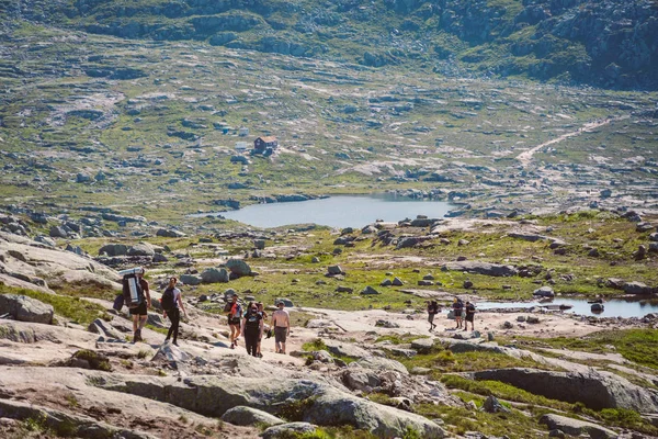 26 iulie 2019. Norvegia traseu turistic pe trolltunga. Oameni turiști merg drumeții în munții Norvegiei în vreme însorită fină la thetrolltunga. Tema rucsac drumeții — Fotografie, imagine de stoc