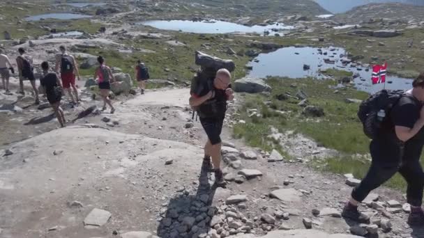 26 de julio de 2019. Noruega ruta turística en la trolltunga. La gente turistas van de excursión en las montañas de Noruega en buen tiempo soleado a la rolltunga. Mochila de senderismo tema — Vídeos de Stock