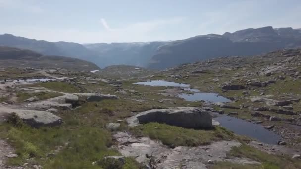 26 lipca 2019. Trasa turystyczna Norwegii na Trolltunga. Ludzie turyści chodzą na wędrówki w górach Norwegii w dobrej słonecznej pogodzie do thetrolltunga. Motyw plecak turystyczny — Wideo stockowe