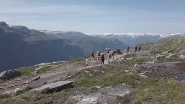26. Juli 2019. norwegische Touristenroute auf der Trolltunga. Menschen Touristen wandern in den Bergen Norwegens bei schönem, sonnigem Wetter auf die Rolltunga. Thema Wanderrucksack — Stockvideo