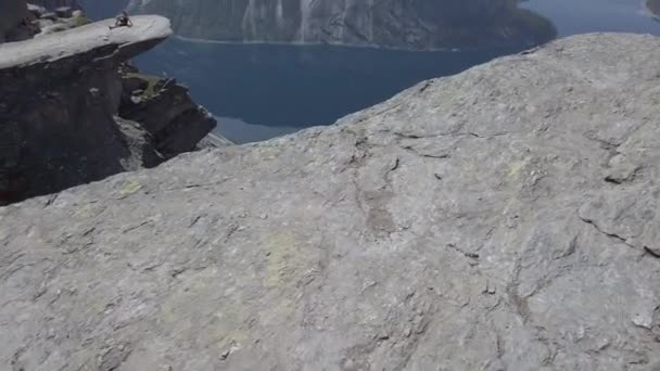 26. července 2019. Norská turistická trasa na trolltungu. Turisté v Norsku jezdí po pěkném slunném počasí do thetrolltungy. Téma turistické batohu — Stock video