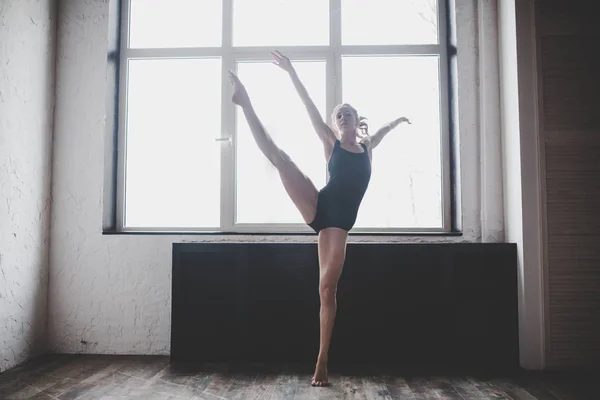 Plasticiteit slanke vrouw dansen in de buurt van venster. Professionele danser geniet van dans. Lady Dancer traint modern ballet in de klas. Hedendaagse dans performer. Daglicht, silhouet mooi lichaam. Dans thema — Stockfoto