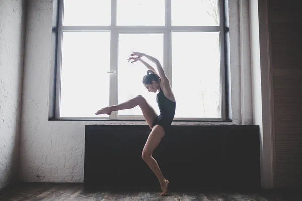 Πλαστικότητα λεπτή γυναίκα που χορεύει κοντά στο παράθυρο. Ο επαγγελματίας χορευτής απολαμβάνει το χορό. Κυρία χορεύτρια εκπαίδευση μοντέρνο μπαλέτο στην τάξη. Σύγχρονος καλλιτέχνης χορού. Φως της μέρας, ωραίο σώμα. Θέμα χορού — Φωτογραφία Αρχείου